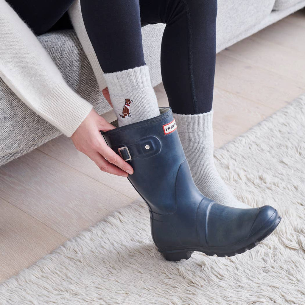 Person wearing Hunter Wellingtons with embroidered dog socks